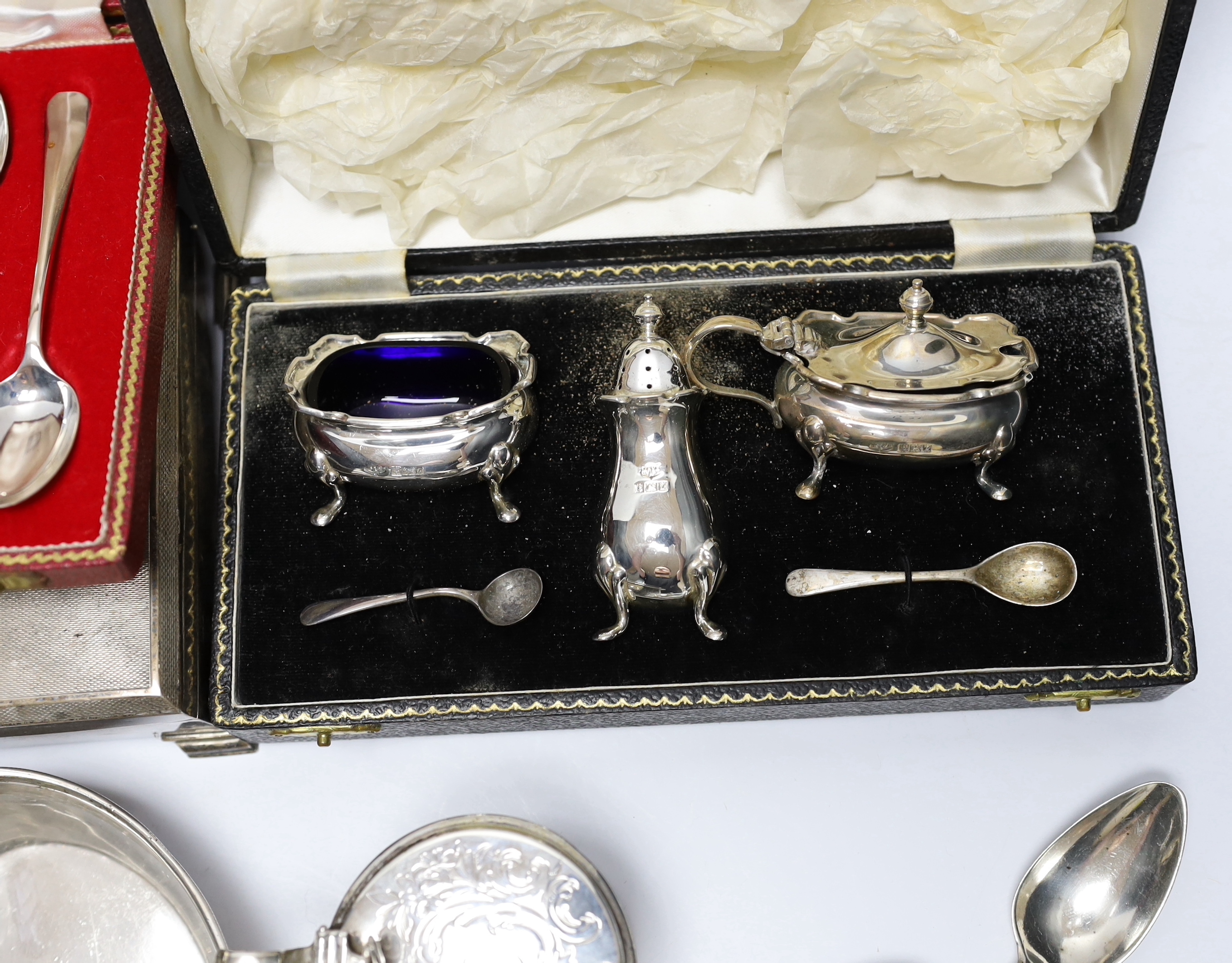 Sundry silver wares including a cigarette box and case, cased condiment set, cased pair of pepperettes and cased set of six teaspoons, sauceboat, Victorian mustard, Victorian mug with angular handle, nine items of flatwa